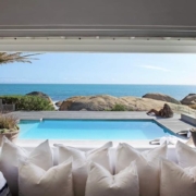 Wide-angle view of a luxury villa in Thailand comparing the space-saving benefits of sliding glass doors against traditional swing doors.