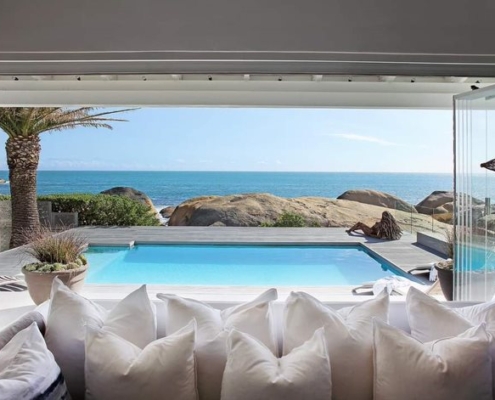 Wide-angle view of a luxury villa in Thailand comparing the space-saving benefits of sliding glass doors against traditional swing doors.