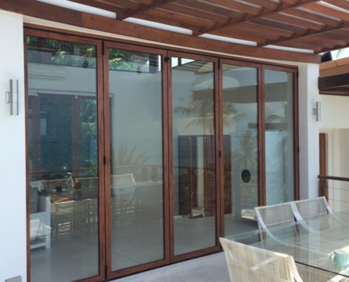 Closed exterior view of the weatherproof SF 45 folding glass wall with dark aluminum frames.