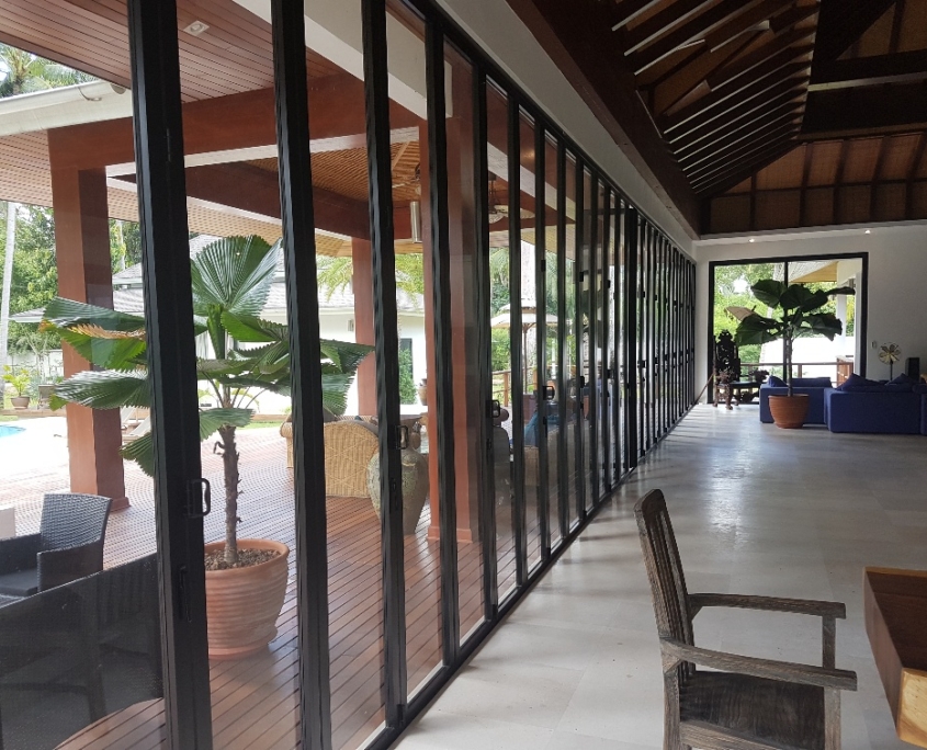 Close-up view of the stacked panels and flush floor track of the SF 45 commercial folding door system.