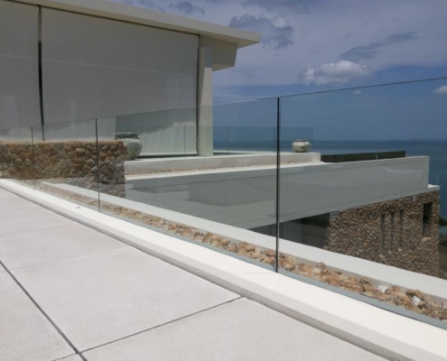 frameless-glass-balustrade-terrace-edge-detail Close-up detail of the frameless safety glass balustrade securing the edge of a modern coastal terrace.