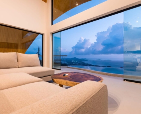 frameless-sliding-doors-ocean-view Frameless sliding doors by Sunflex offering an unobstructed ocean view from a living room