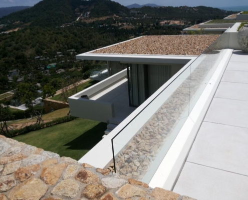 glass-balustrade-coastal-terrace-safety-barrier A robust Sunflex glass balustrade providing an enduring safety barrier on a modern terrace with clear ocean views.