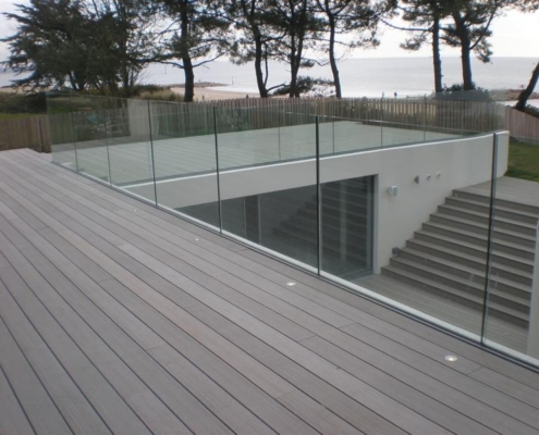 glass-balustrade-for-stairs-wooden-deck-safety Frameless glass balustrade providing multi-level safety along a modern wooden deck and staircase.
