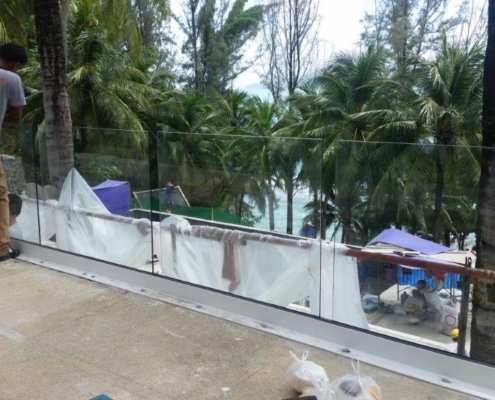 glass-balustrade-installation-team-on-site A professional team installs the structural base and fittings for a Sunflex frameless glass balustrade system on-site.