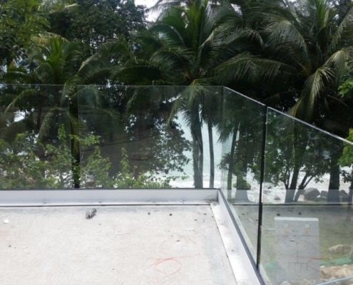 glass-balustrade-tropical-setting-coastal-development Frameless safety glass railing system blending with the tropical environment of a coastal development project in Thailand.