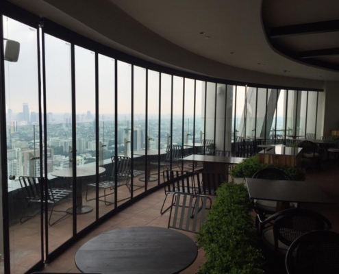 Aluminum framed SF 25 slide and turn enclosure offering a panoramic view of the Bangkok skyline.