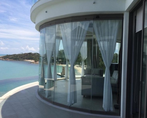 sf25-circular-glass-sunroom-sea-view Circular sunroom with SF 25 frameless glazing offering a breathtaking 180-degree sea view.