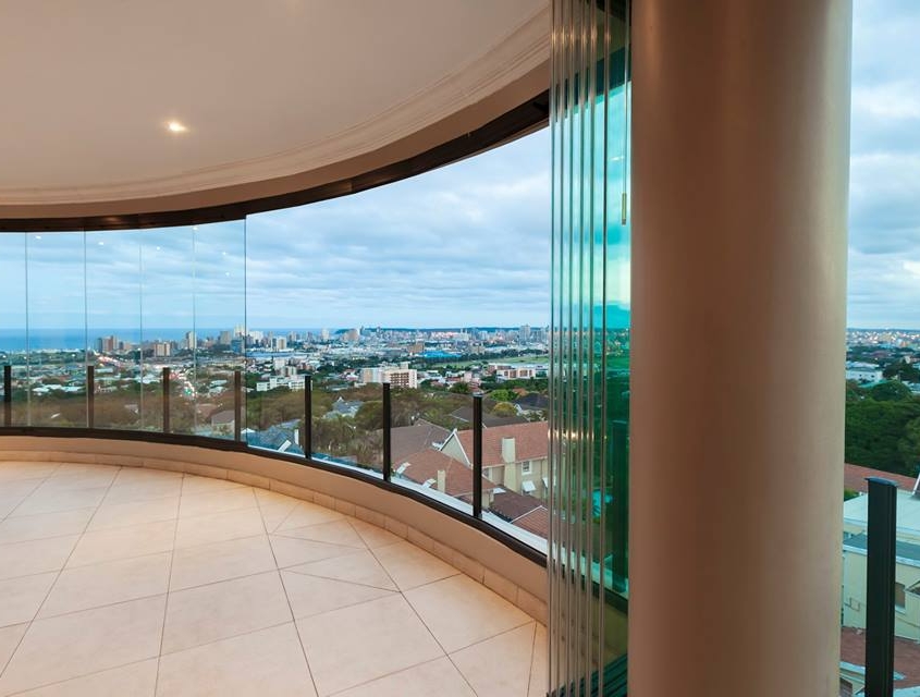 sf25-curved-glass-wall-parked-panels Frameless glass panels of the SF 25 system parked against a pillar on a curved balcony.