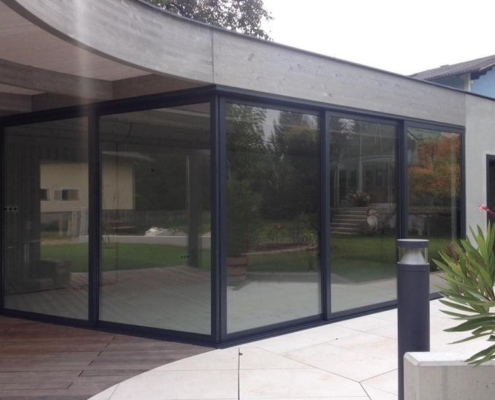 sf42-exterior-corner-sliding-glass-wall Exterior view of a corner glass wall installation using the SUNFLEX SF 42 framed system