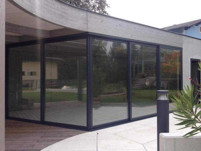 sf42-exterior-corner-sliding-glass-wall Exterior view of a corner glass wall installation using the SUNFLEX SF 42 framed system