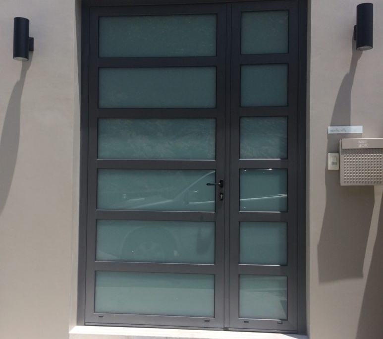 sf45-modern-aluminum-entrance-door-thailand Modern SUNFLEX SF 45 aluminum entrance door with frosted glass panels installed in a luxury home.