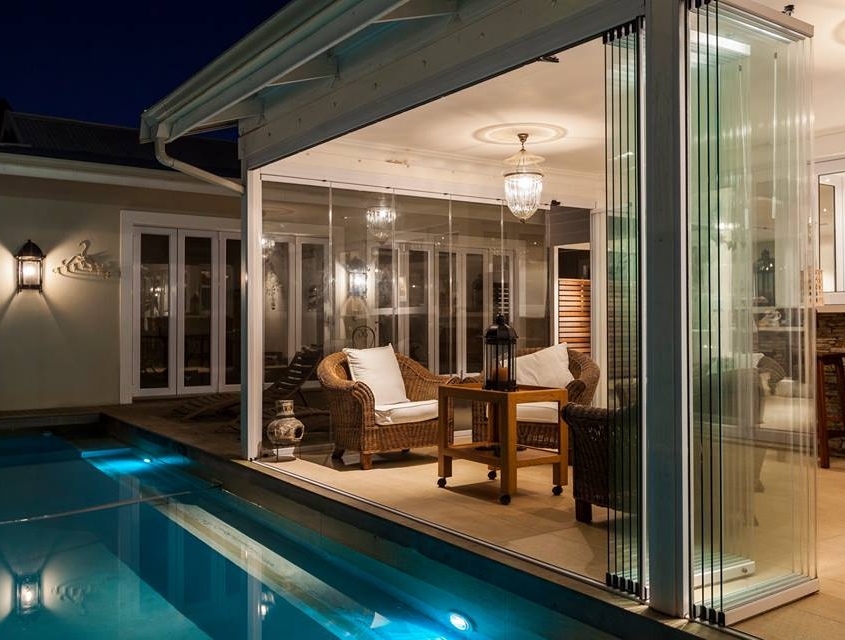 sunflex-sf25-evening-villa-interior-poolside Warmly lit villa interior with SF 25 slide and turn doors leading to a private pool.