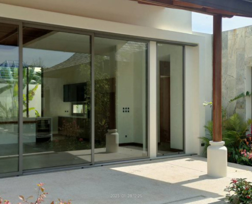 sunflex-sf26-aluminum-sliding-doors-modern-living-thailand Interior view of a modern living area with Sunflex SF 26 aluminum sliding doors opening to a tropical garden in Thailand.
