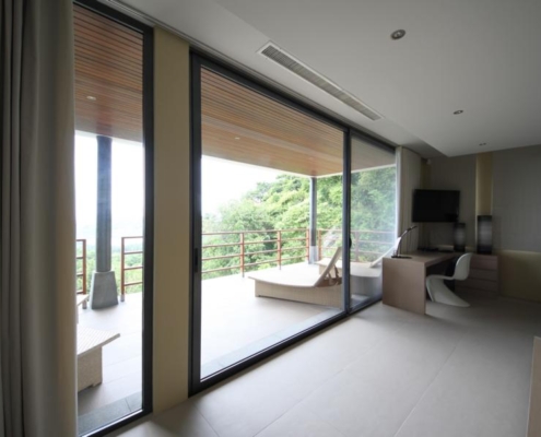 sunflex-sf42-aluminum-framed-sliding-door-interior Interior view of SUNFLEX SF 42 aluminum framed sliding doors opening onto a tropical balcony.