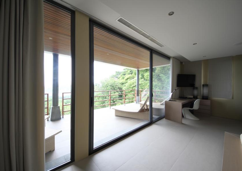 sunflex-sf42-aluminum-framed-sliding-door-interior Interior view of SUNFLEX SF 42 aluminum framed sliding doors opening onto a tropical balcony.