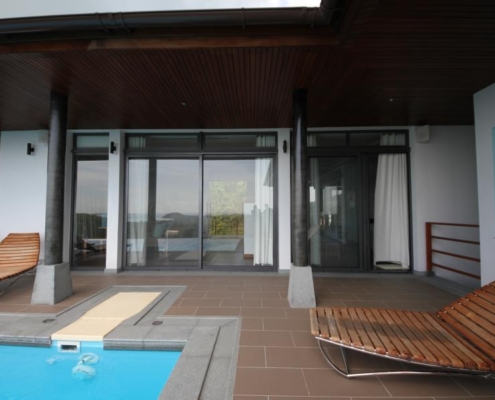 sunflex-sf42-patio-doors-poolside-view Poolside view of a luxury villa featuring SUNFLEX SF 42 aluminum patio doors.