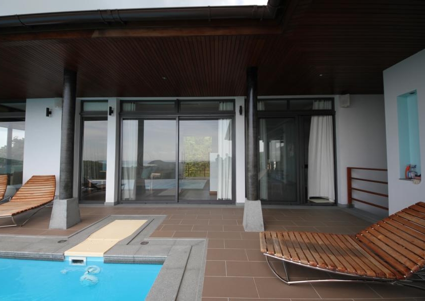 sunflex-sf42-patio-doors-poolside-view Poolside view of a luxury villa featuring SUNFLEX SF 42 aluminum patio doors.