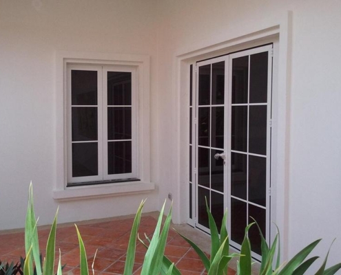 white-aluminum-casement-window-door-exterior Matching white SF 45 aluminum casement window and door system installed in a residential courtyard.