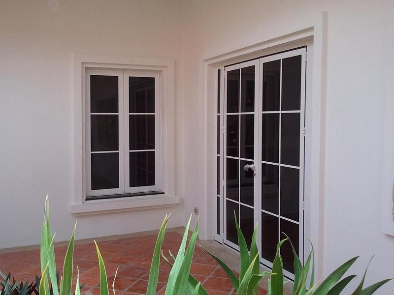 white-aluminum-casement-window-door-exterior Matching white SF 45 aluminum casement window and door system installed in a residential courtyard.
