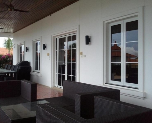 white-aluminum-french-doors-patio-sf45 White powder-coated SF 45 aluminum French doors and windows complementing a modern home exterior.