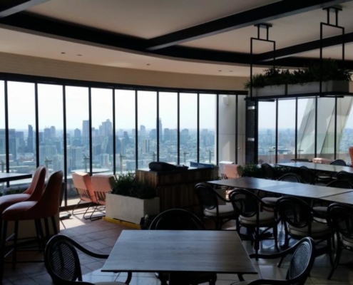 Windproof and noise-reducing SF 25 slide and turn glass system for a rooftop dining area.