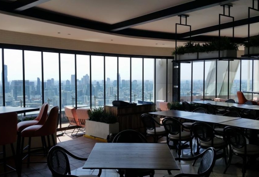 Windproof and noise-reducing SF 25 slide and turn glass system for a rooftop dining area.